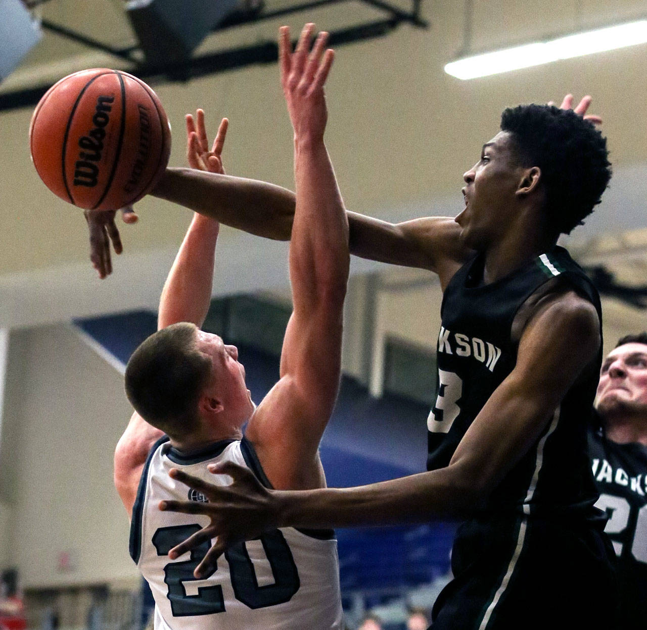 Jackson’s Jaylen Searles (right) blocks a shot attempt by Glacier Peak’s Fletcher Douglas during a Wesco 4A boys basketball game Wednesday at Glacier Peak High School in Snohomish. Searles was called for a foul on the play, but the Timberwolves beat the Grizzlies 47-44. (Kevin Clark / The Herald)