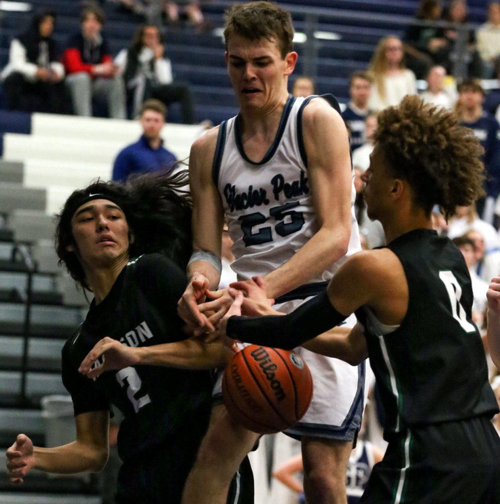 From left, Jackson’s Jesse Hoiby, Glacier Peak’s Noah Forman and Jackson’s Christian Liddell scramble for a loose ball during a Wesco 4A boys basketball game Wednesday at Glacier Peak High School in Snohomish. Jackson beat the Grizzlies 47-44. (Kevin Clark / The Herald)
