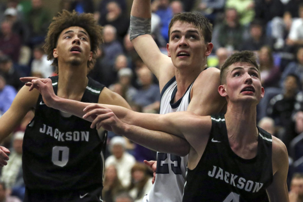 Jackson’s Christian Liddell (left-right) Glacier Peak’s Noah Forman and Jackson’s Carter Korab look to rebound off a free throw at Glacier Peak High School Friday night in Snohomish on January 30, 2019. The Timberwolves won 47-44. (Kevin Clark / The Herald)
