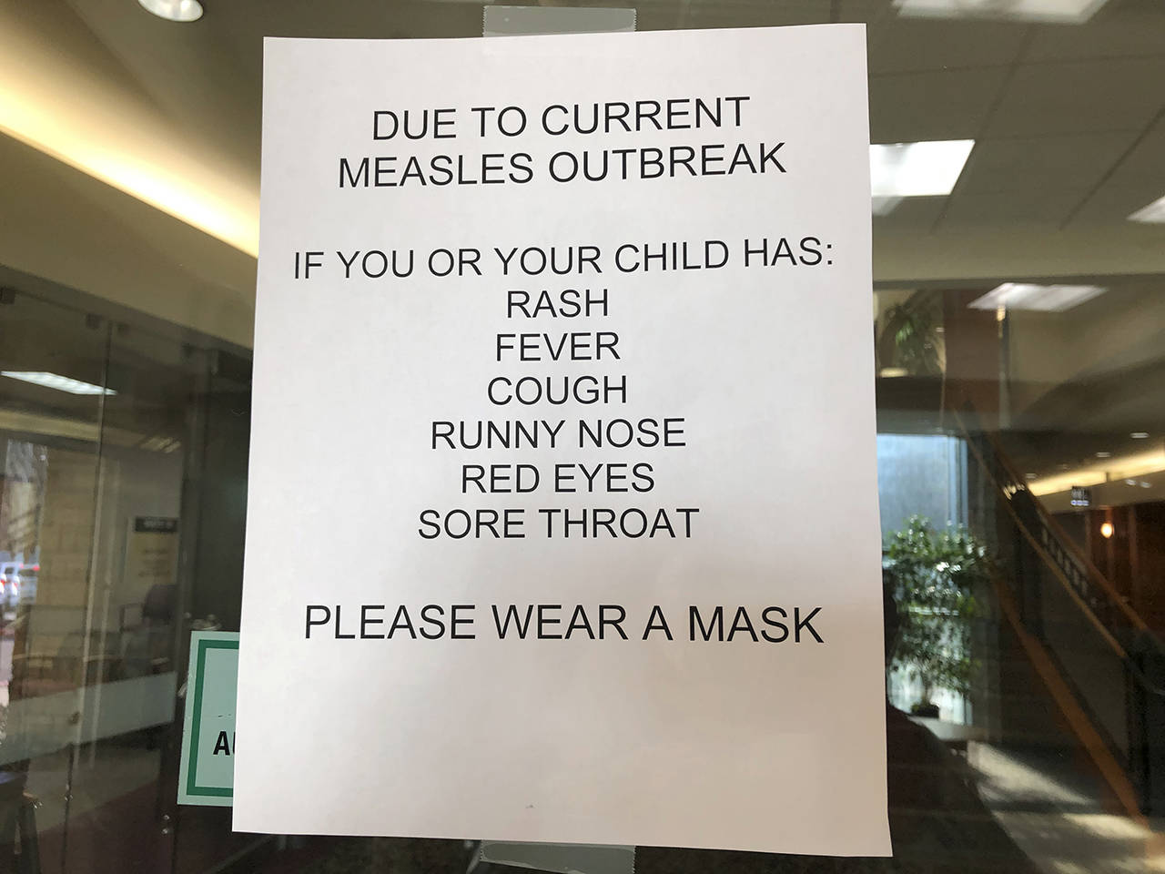 Signs posted at The Vancouver Clinic in Vancouver, Washington, warn patients and visitors of a measles outbreak on Wednesday. The outbreak has sickened 39 people in the Pacific Northwest, with 13 more cases suspected. (AP Photo/Gillian Flaccus)