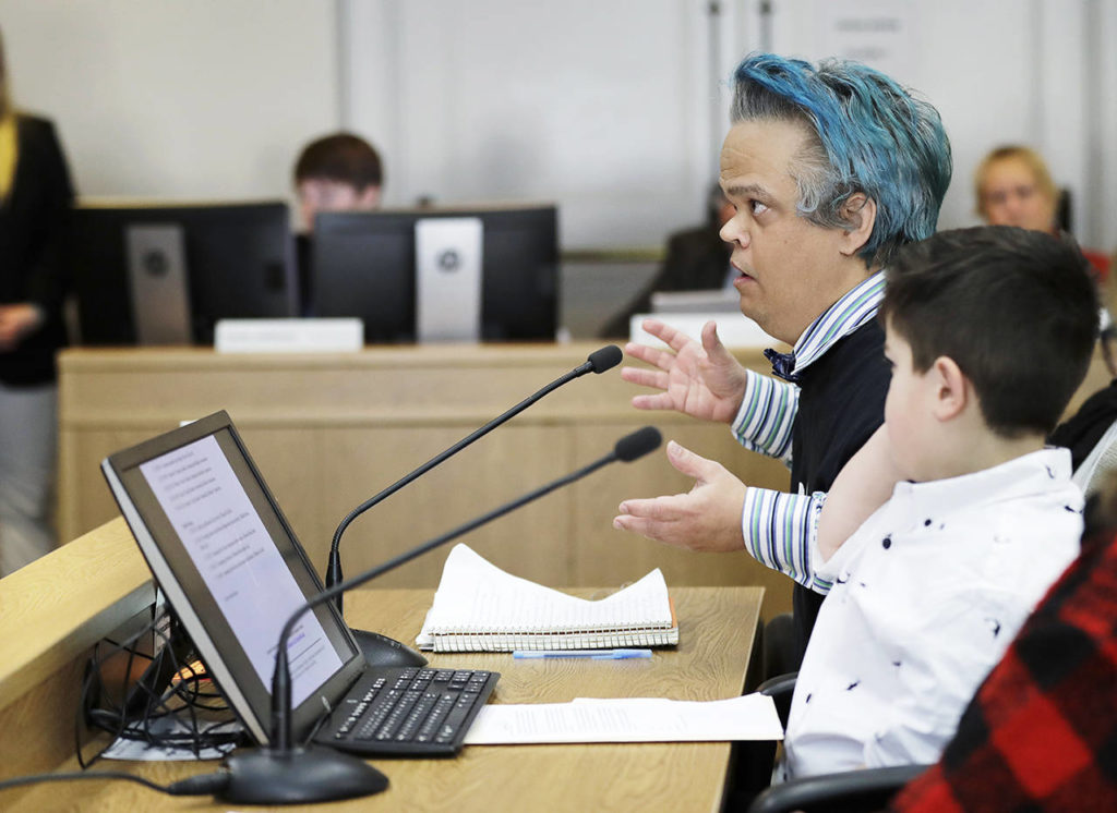 Peter Reckendorf (left), of Everett, testifies Thursday before the Senate Law and Justice Committee of the Legislature in favor of a proposed statewide ban on risky entertainment events, including dwarf tossing, that feature people with dwarfism. (AP Photo/Ted S. Warren) 
