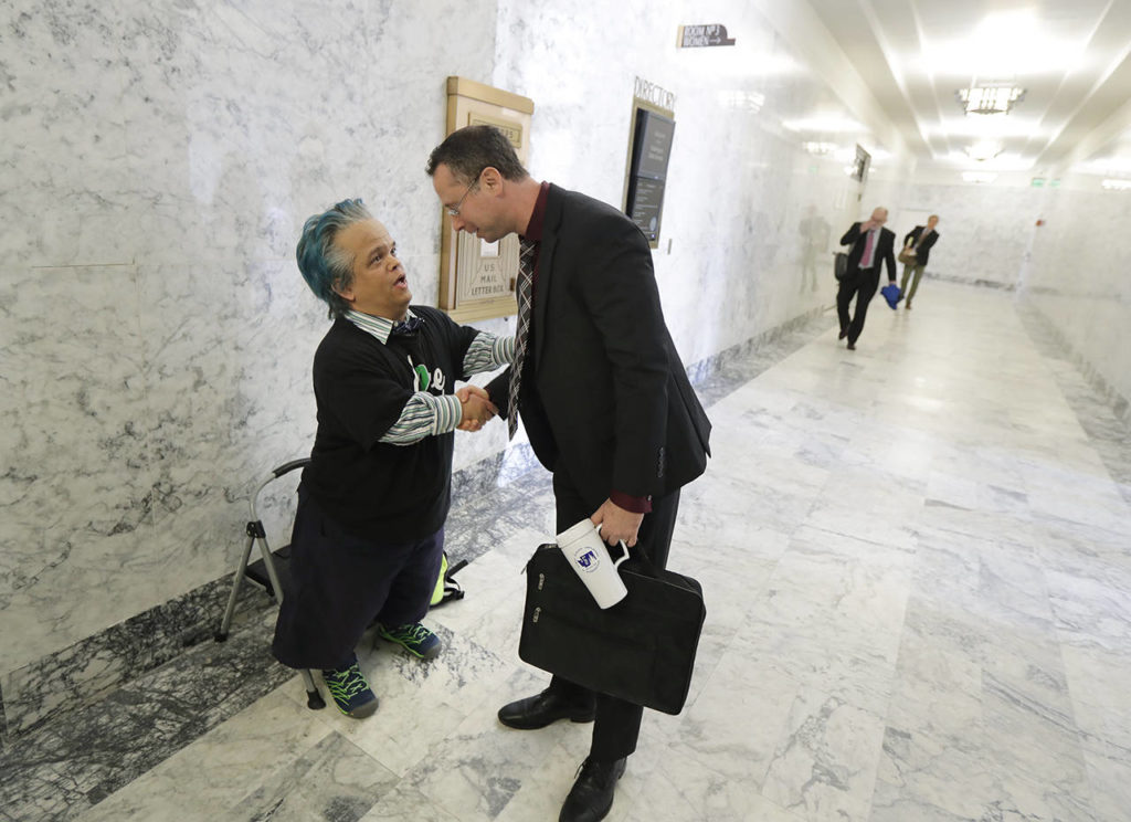 Peter Reckendorf (left), of Everett, talks with Sen. Sen. Jesse Salomon, D-Shoreline, on Thursday in Olympia before Reckendorf testified before the Senate Law and Justice Committee of the Legislature in favor of a proposed statewide ban on risky entertainment events, including dwarf tossing, that feature people with dwarfism. (AP Photo/Ted S. Warren)
