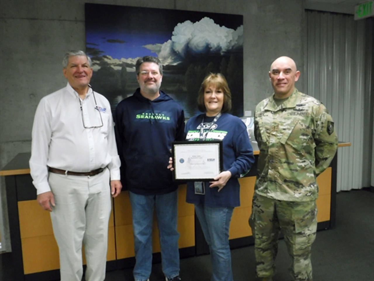 Holly Faller (with certificate), a Snohomish County planning department supervisor, was recognized on Jan. 4 for her support of employees who serve in the military. She was nominated by Dave Lente (far right), an Army reservist who works in her office. (Snohomish County)