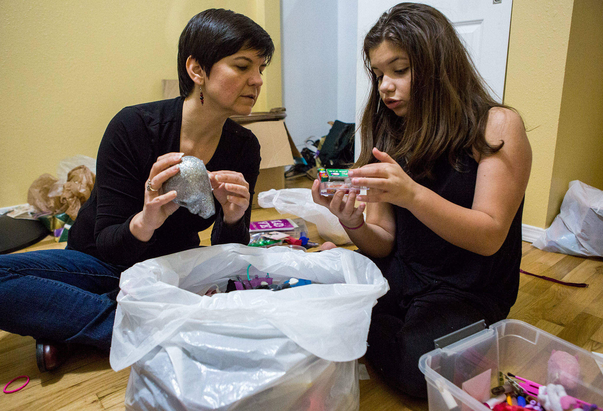 Diane Bradford, left, and her daughter Sierra Lindenstein, 11, sort through the last few bags of their donate stuff at their home in Lynnwood. (Olivia Vanni / The Herald)