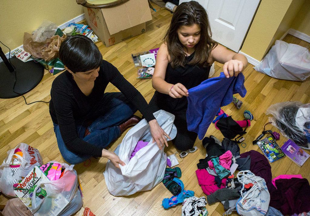 Diane Bradford, left, and her daughter Sierra Lindenstein, 11, sort through clothing at their home in Lynnwood. (Olivia Vanni / The Herald)
