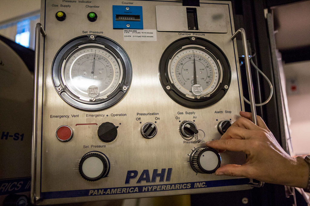 A nurse adjusts the chamber pressurization at EvergreenHealth’s Wound Care and Hyperbarics Center in Monroe. (Olivia Vanni / The Herald)
