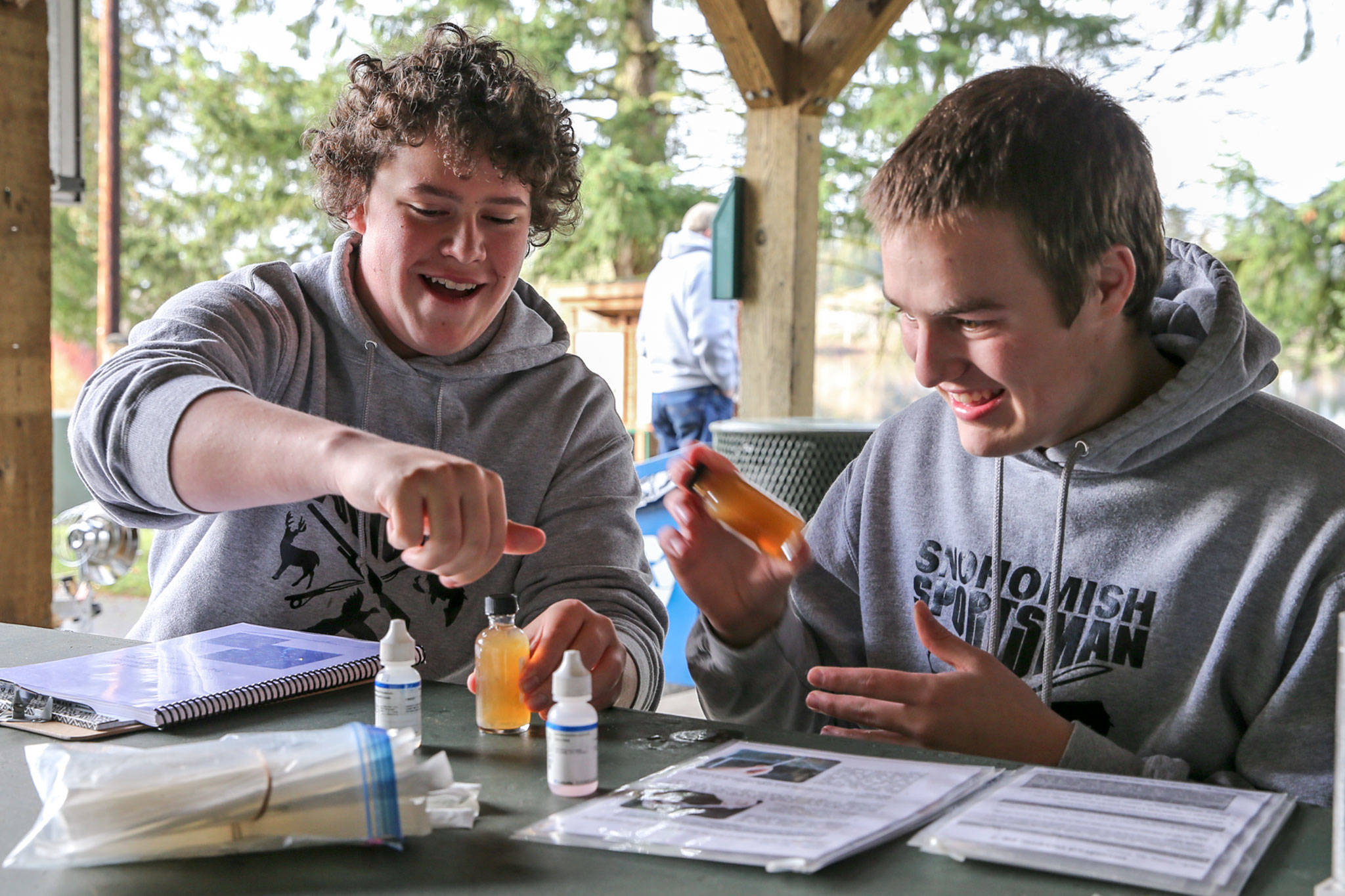 David Rossall (left) and Errol Hooker share a laugh while testing the waters of Blackmans Lake at Hill Park in Snohomish on Saturday morning. (Kevin Clark / The Herald)