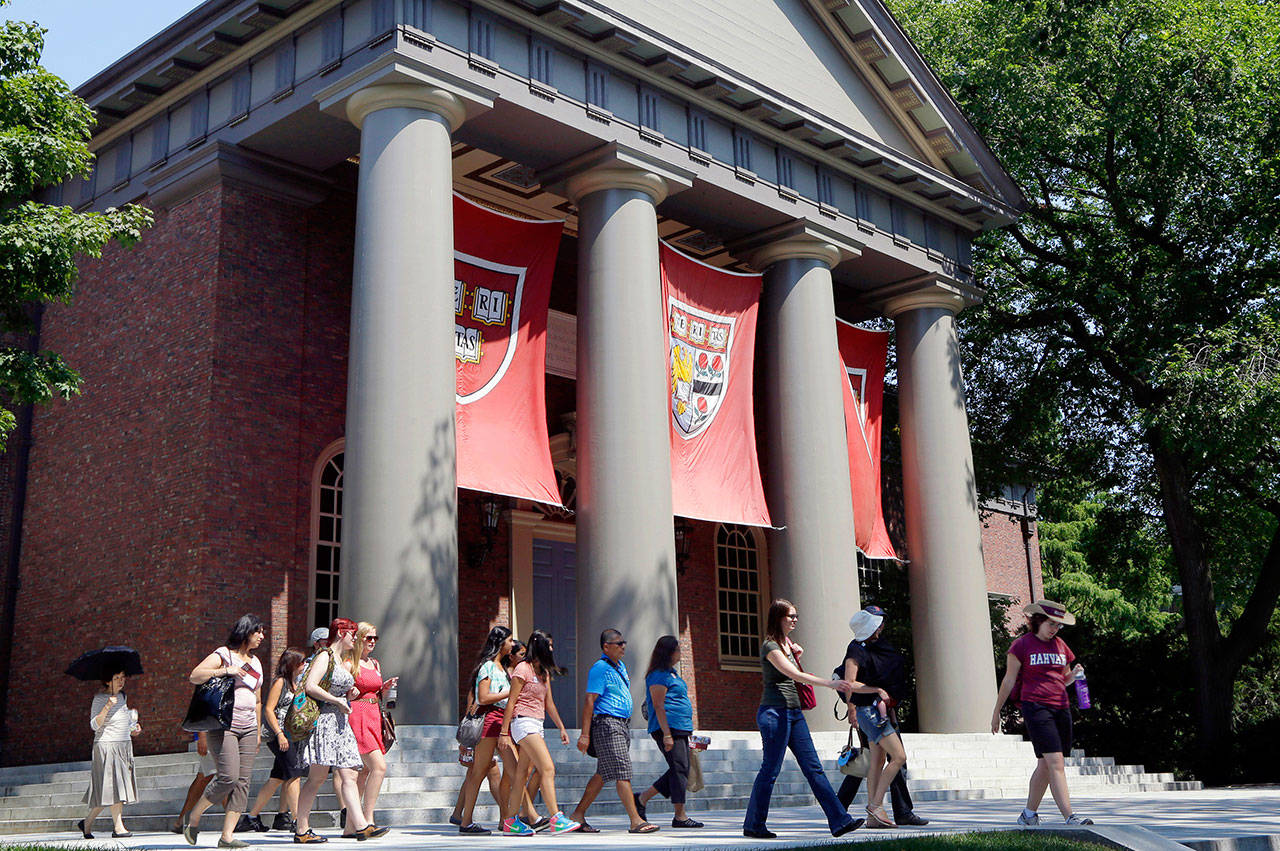 A tour group walks through the campus of Harvard University in Cambridge, Massachusetts. Hundreds of U.S. universities made strong returns on their financial investments last year, but experts worry the gains could be jeopardized by increased spending at many schools.(AP Photo/Elise Amendola, File)