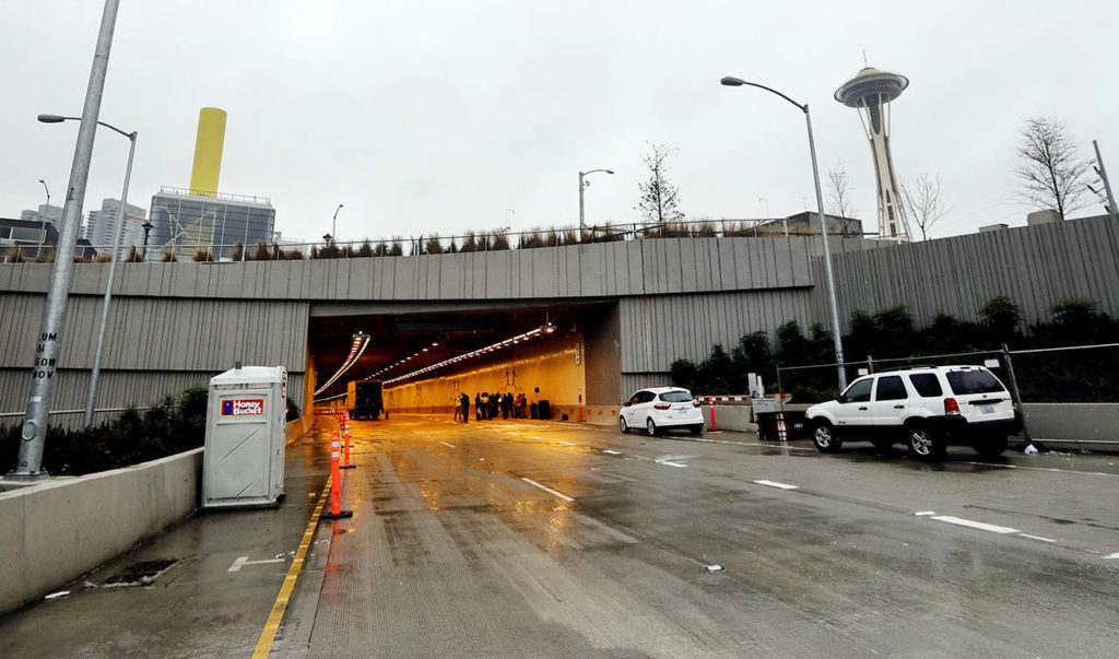 A small group gathers just inside the southbound roadway at the north portal of the new State Route 99 tunnel on Friday in Seattle. (AP Photo/Elaine Thompson)
