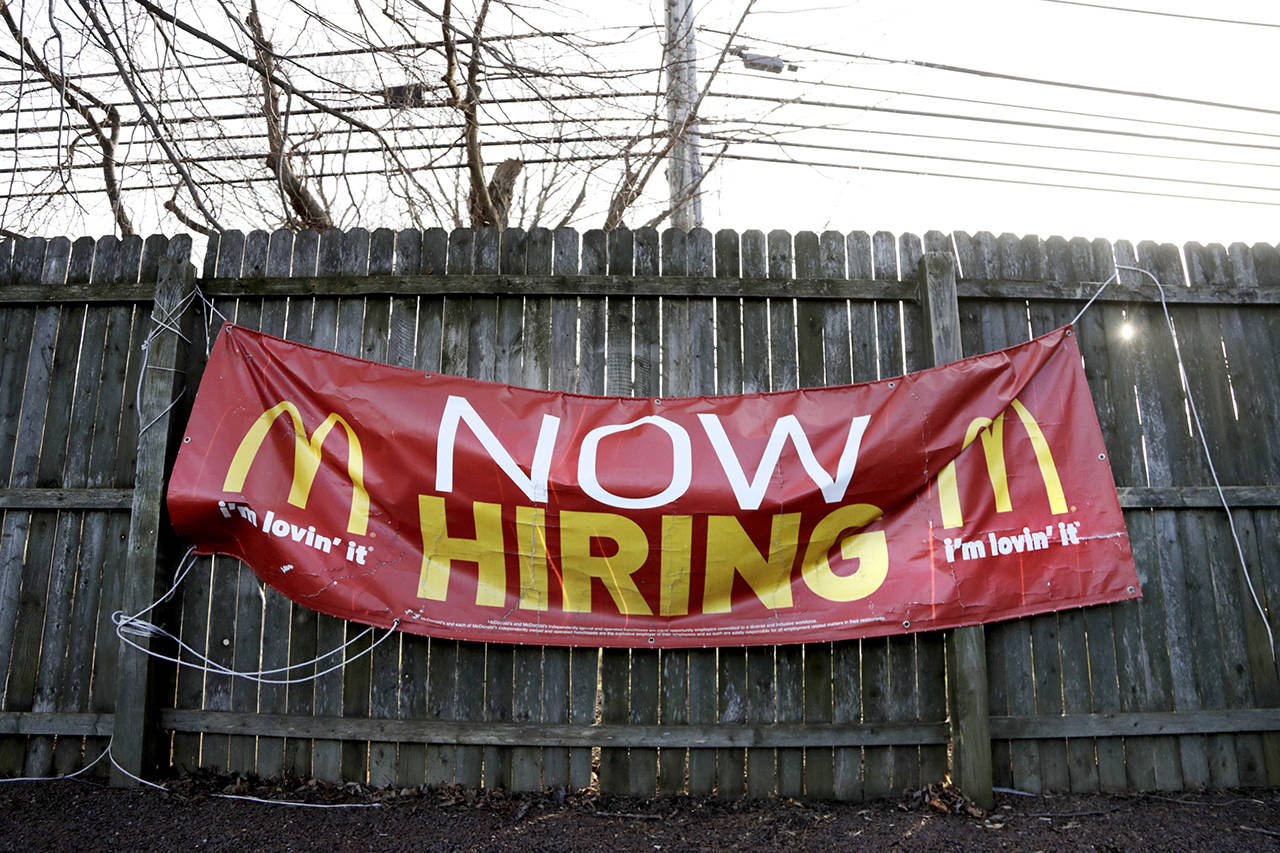 In this Jan. 3 photo, an employment sign hangs from a wooden fence on the property of a McDonald’s restaurant in Atlantic Highlands, New Jersey. (AP Photo/Julio Cortez, File)
