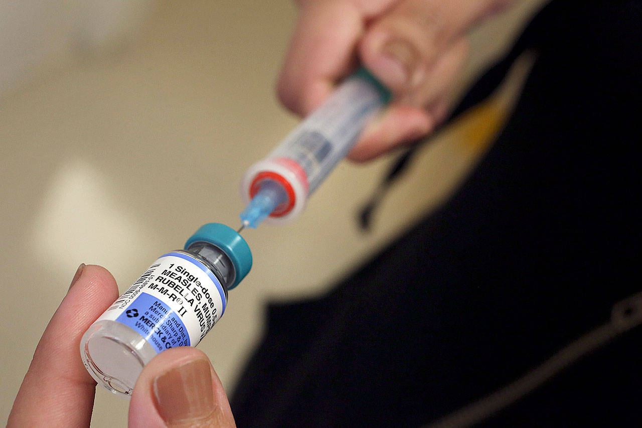 A vial containing the MMR vaccine is loaded into a syringe before being given to a baby at the Medical Arts Pediatric Med Group in Los Angeles in 2015. (Los Angeles Times file)