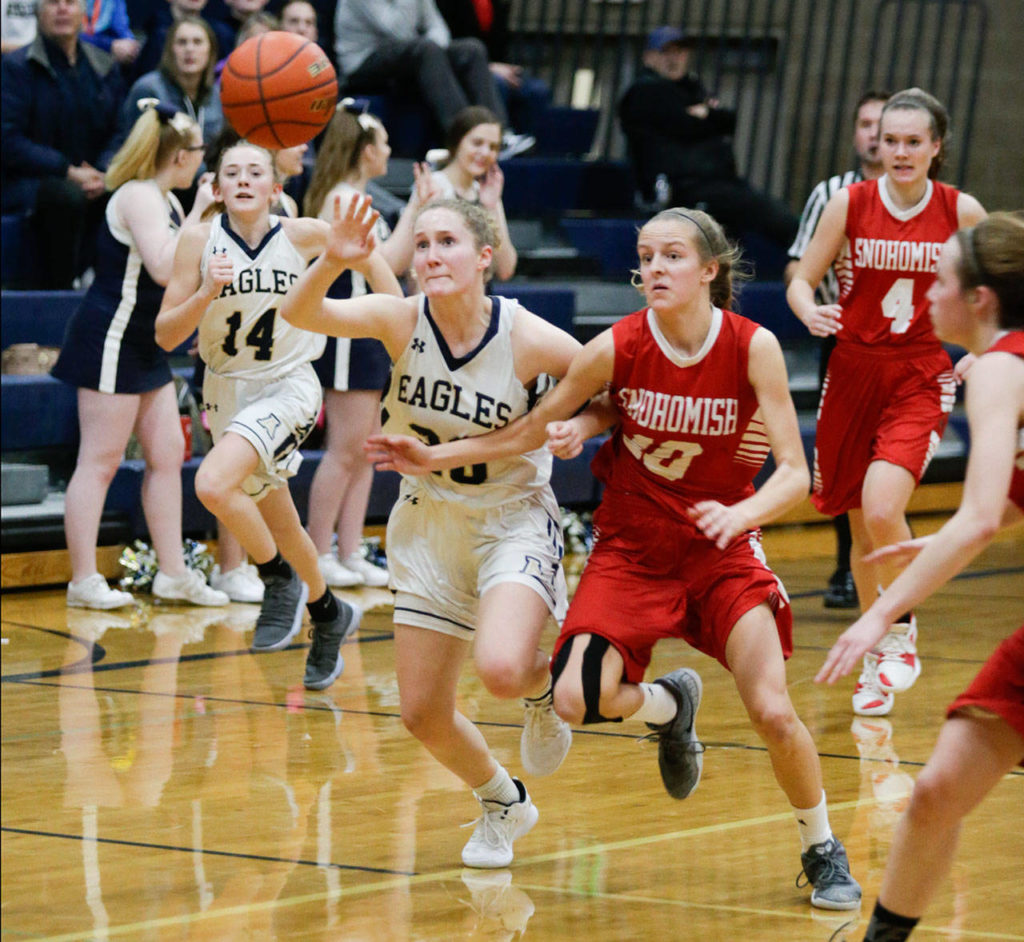 Arlington’s Sierra Scheppele (left) battles Snohomish’s Kayla Soderstrom for a loose ball during Friday’s game in Arlington. (Andy Bronson / The Herald)
