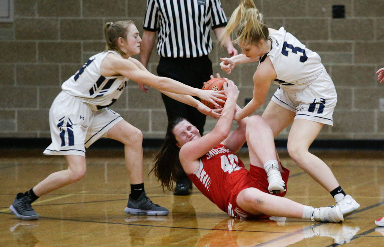 Snohomish’s Courtney Perry (bottom) fights for the ball against Arlington’s Keira Marsh (left) and Abby Schwark (3) during Friday’s game in Arlington. (Andy Bronson / The Herald)
