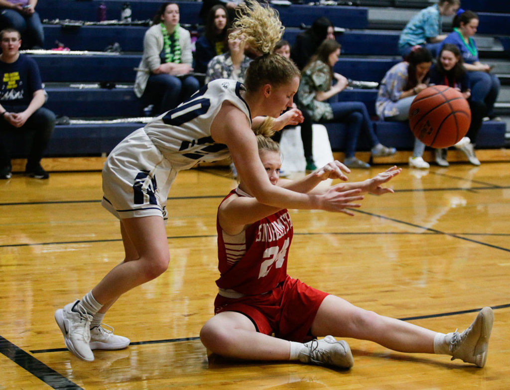 Snohomish’s Kaylin Beckman (bottom) throws a pass as she’s guarded by Arlington’s Sierra Scheppele during a game on Friday in Arlington. (Andy Bronson / The Herald)
