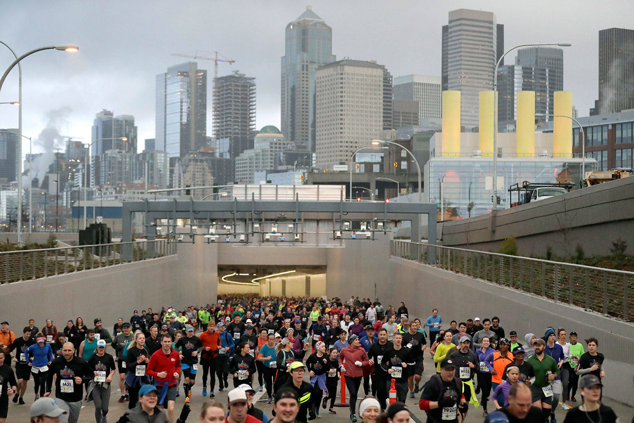 Thousands of runners emerge Saturday from the new tunnel that will replace the Alaskan Way Viaduct in downtown Seattle as they take part in an 8k run to mark the planned Monday grand opening of the tunnel. (AP Photo/Ted S. Warren)