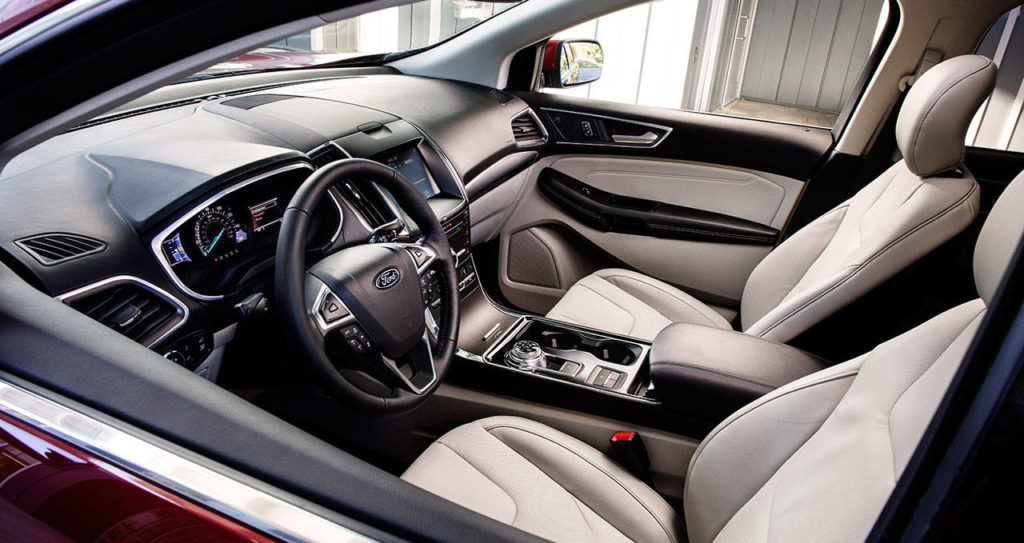 The 2019 Ford Edge infotainment system uses knobs and switches in place of the strictly touch-and-swipe operation of the previous model. The Edge Titanium interior is shown here. (Manufacturer photo)
