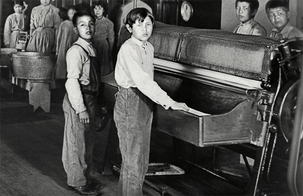 Children at the Tulalip Indian Boarding School not only had studies and religious requirements, they were forced to work. Here, boys are using a mangle iron on laundry day. (Tulalip Tribes Hibulb Cultural Center)
