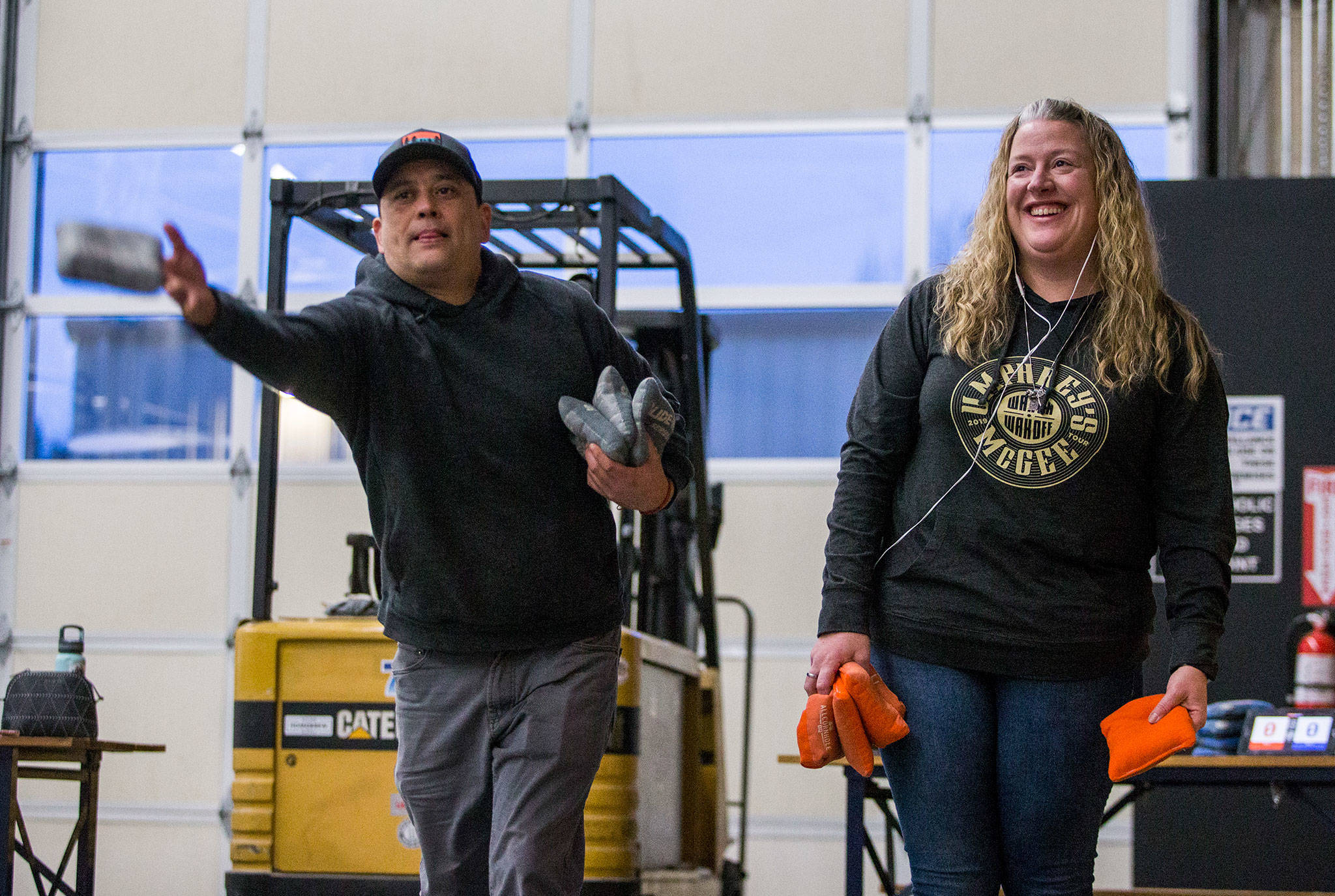 Trassen Oppelt (left) and Tera Streit warm up before a weekly cornhole tournament at Bosk Brew Works in Woodinville on Thursday. (Olivia Vanni / The Herald)