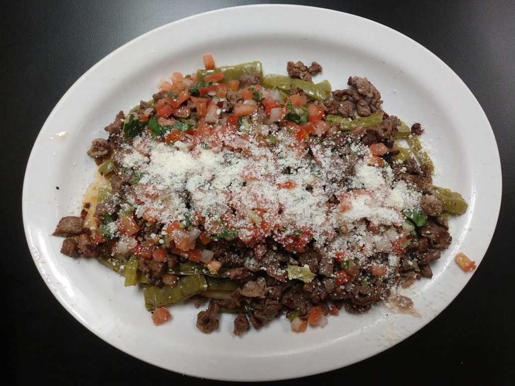 One of Tía Lety’s bestsellers is the huarache. It’s made with a corn dough base, fried in an oblong shape and topped with smashed pinto beans, queso fresco and a variety of other toppings. The dish gets its Spanish name from its sandal-like shape. (Sara Bruestle / The Herald)
