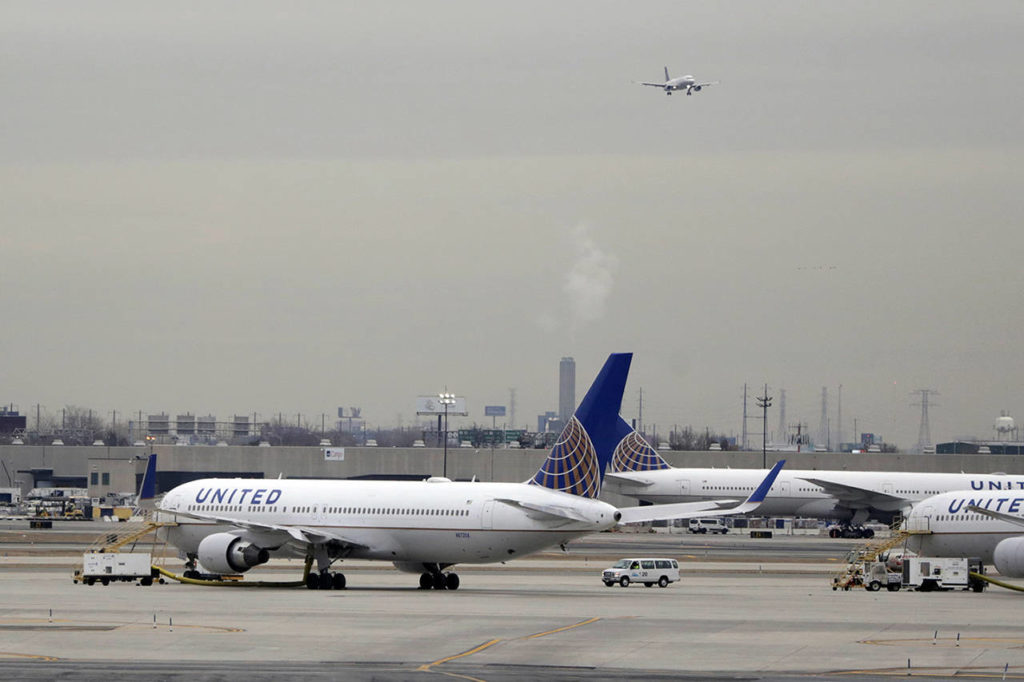 United Airlines jets are seen as a plane approaches Newark Liberty International Airport, in Newark, New Jersey. United Airlines will woo high-fare passengers by retrofitting more than 100 planes to add more premium seats on key routes. (AP Photo/Julio Cortez, File)
