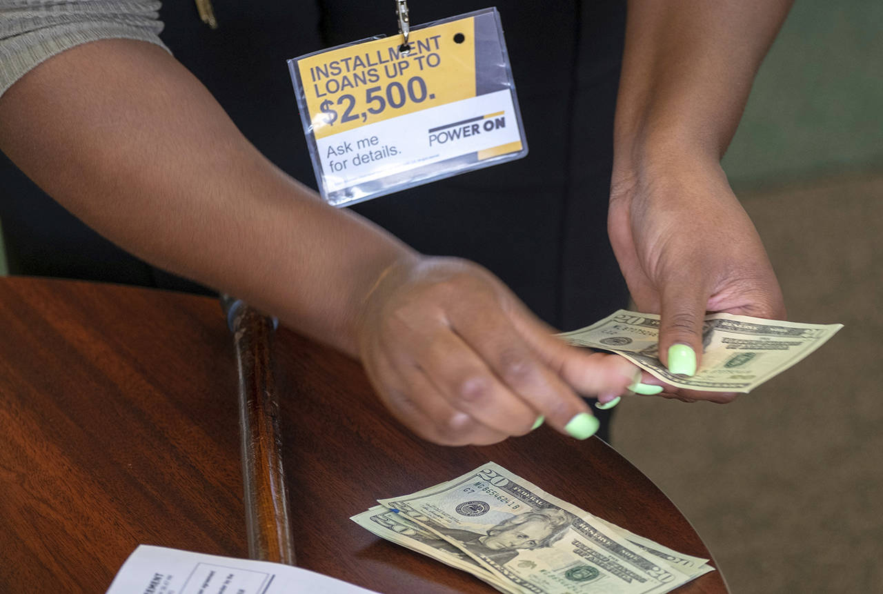 A manager of a financial services store in Missouri counts cash being paid to a client as part of a loan. The nation’s federal financial watchdog has announced its plans to roll back most of its consumer protections governing the payday lending industry. (AP Photo/Sid Hastings, File)