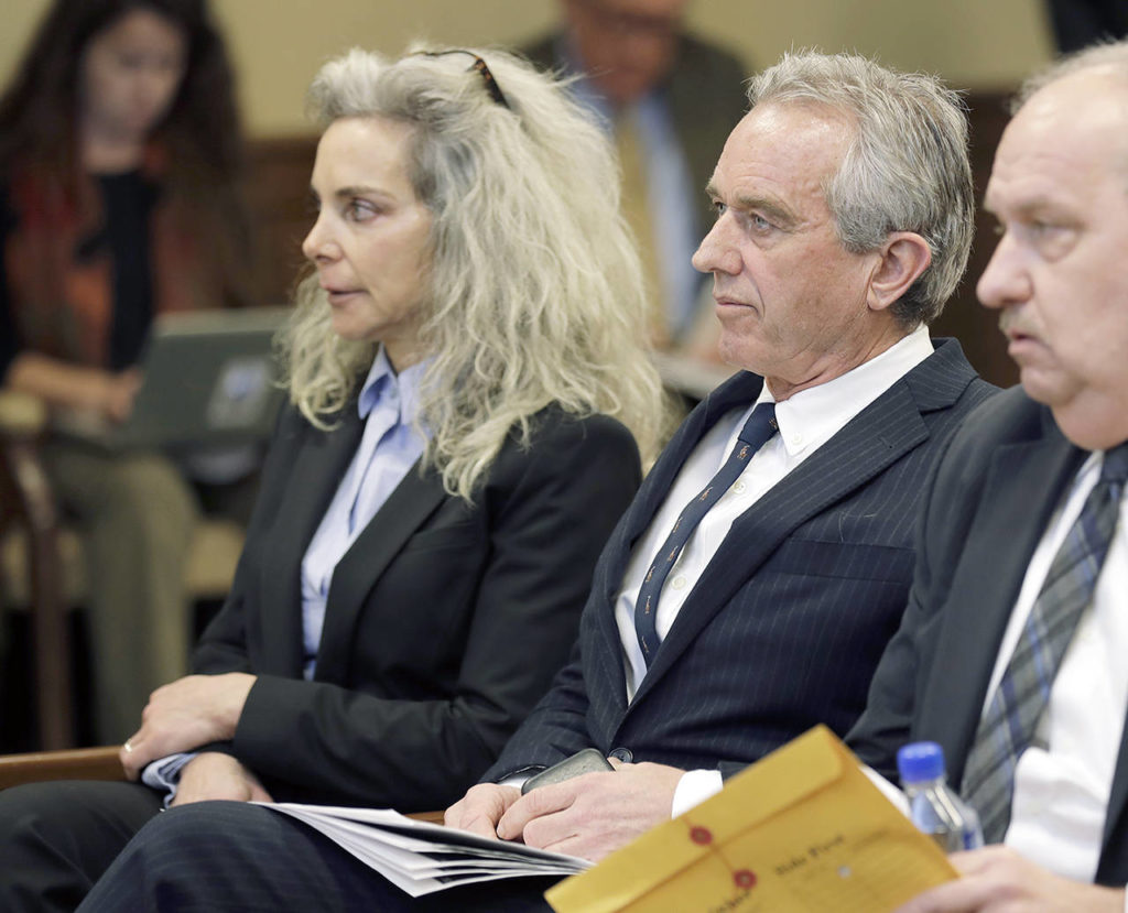 Robert Kennedy Jr. (center) and Dr. Toni Bark (left) wait to testify Friday during a public hearing before the House Health Care & Wellness Committee at the Capitol in Olympia. (AP Photo/Ted S. Warren)
