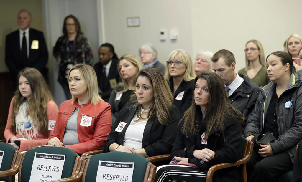 People opposed to a bill that would remove parents’ ability to claim a philosophical exemption to opt their school-age children out of the combined measles, mumps and rubella vaccine listen to testimony Friday at the Capitol in Olympia. (AP Photo/Ted S. Warren)
