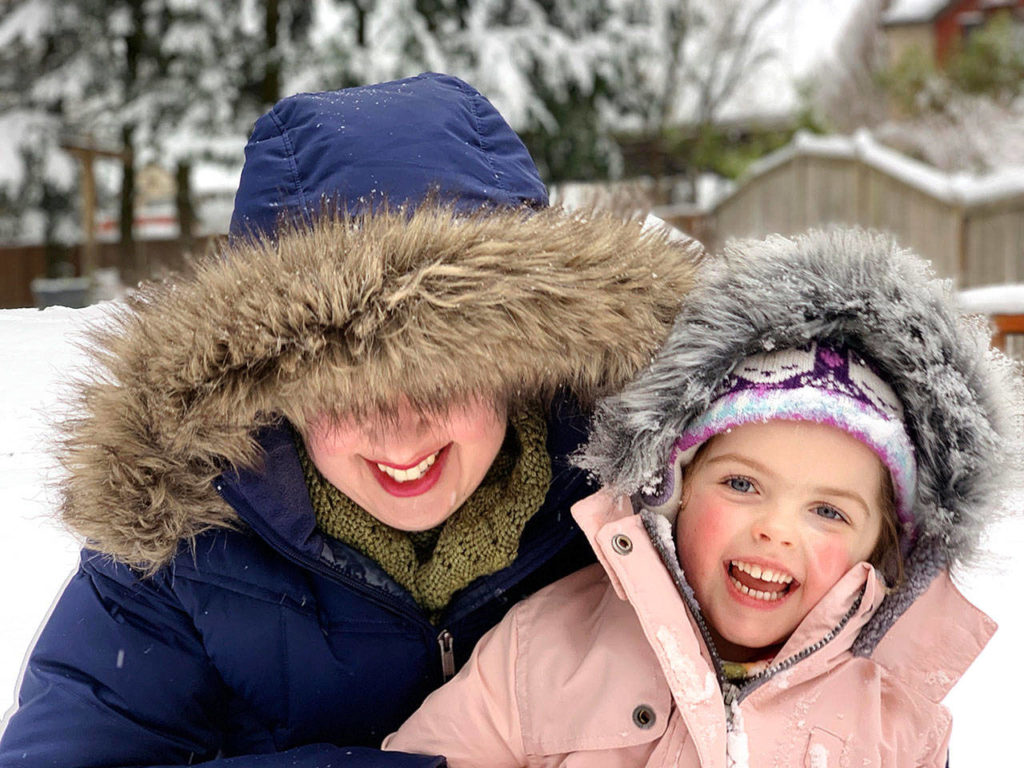Mother and daughter Naomi and Josephine Davis spent an afternoon sledding and making snow angles in their south Everett back yard. The 4-year-old “was very excited to finally get to wear her new snow coat,” her father says. (Nate Davis)
