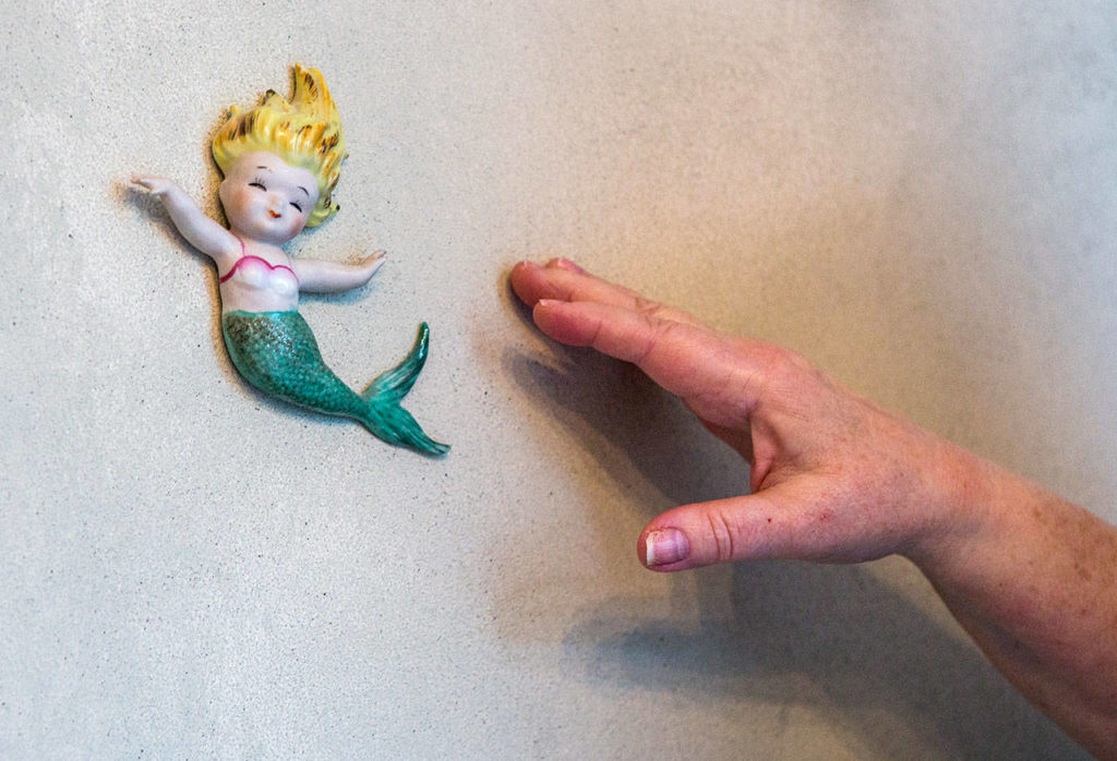 Melissa Strash points out the mermaid that started her love for mermaid collectibles. (Olivia Vanni / The Herald)
