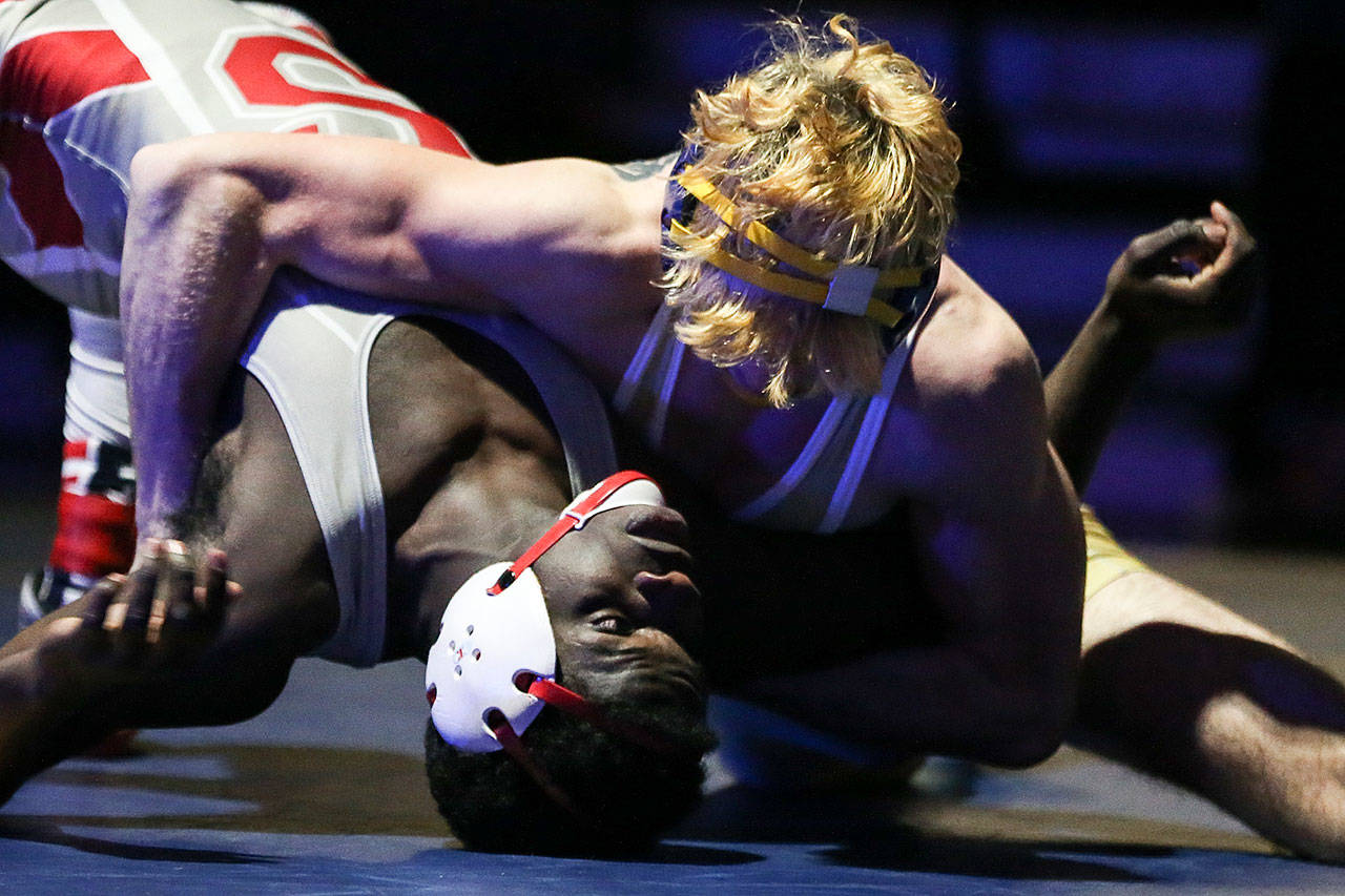 Everett’s Riley Bennett (top) attempts to pin Stanwood’s Jeremy Williams during a match on Jan. 19 at Everett High School. (Kevin Clark / Herald file)