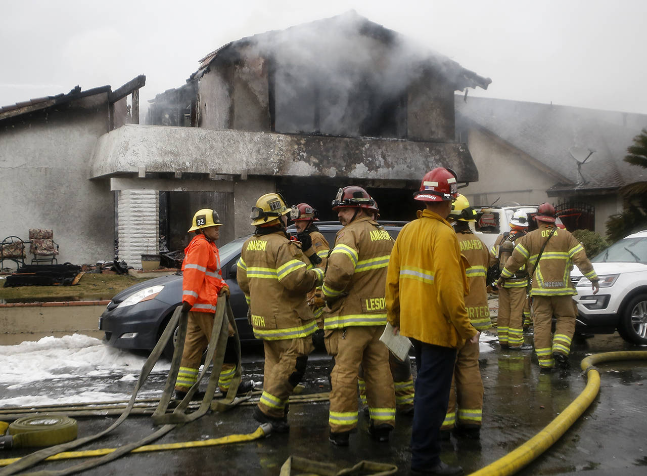 In this Feb. 3 photo, firefighters suppress a fire at the scene of a deadly plane crash in the residential neighborhood of Yorba Linda, California. (AP Photo/Alex Gallardo, File)