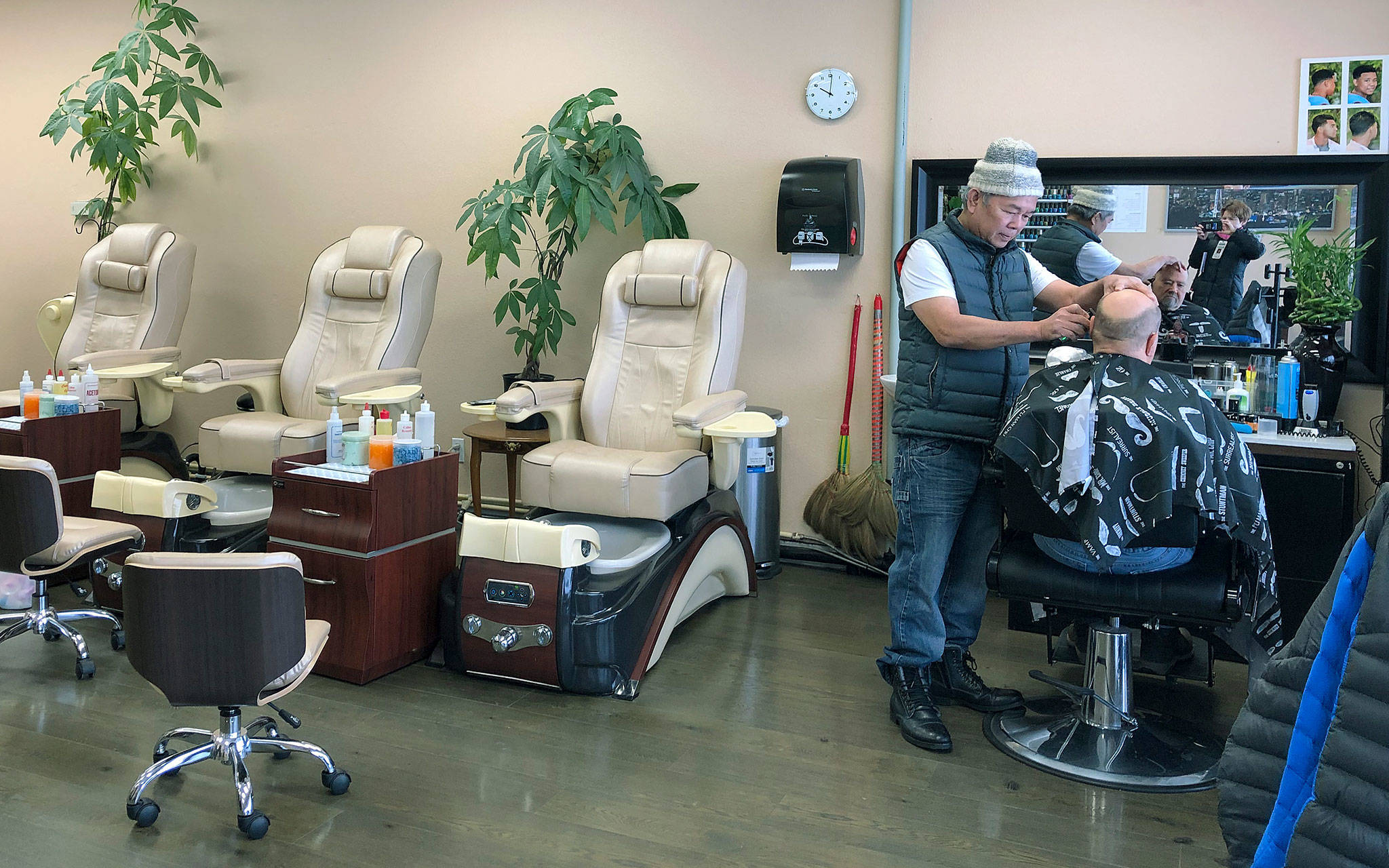 Tommy Nguyen, owner of Tommy Barber Nail Spa in Everett, cuts a customer’s hair Monday. Nguyen closed the nail salon four days ago for a lack of business. (Janice Podsada / The Herald)