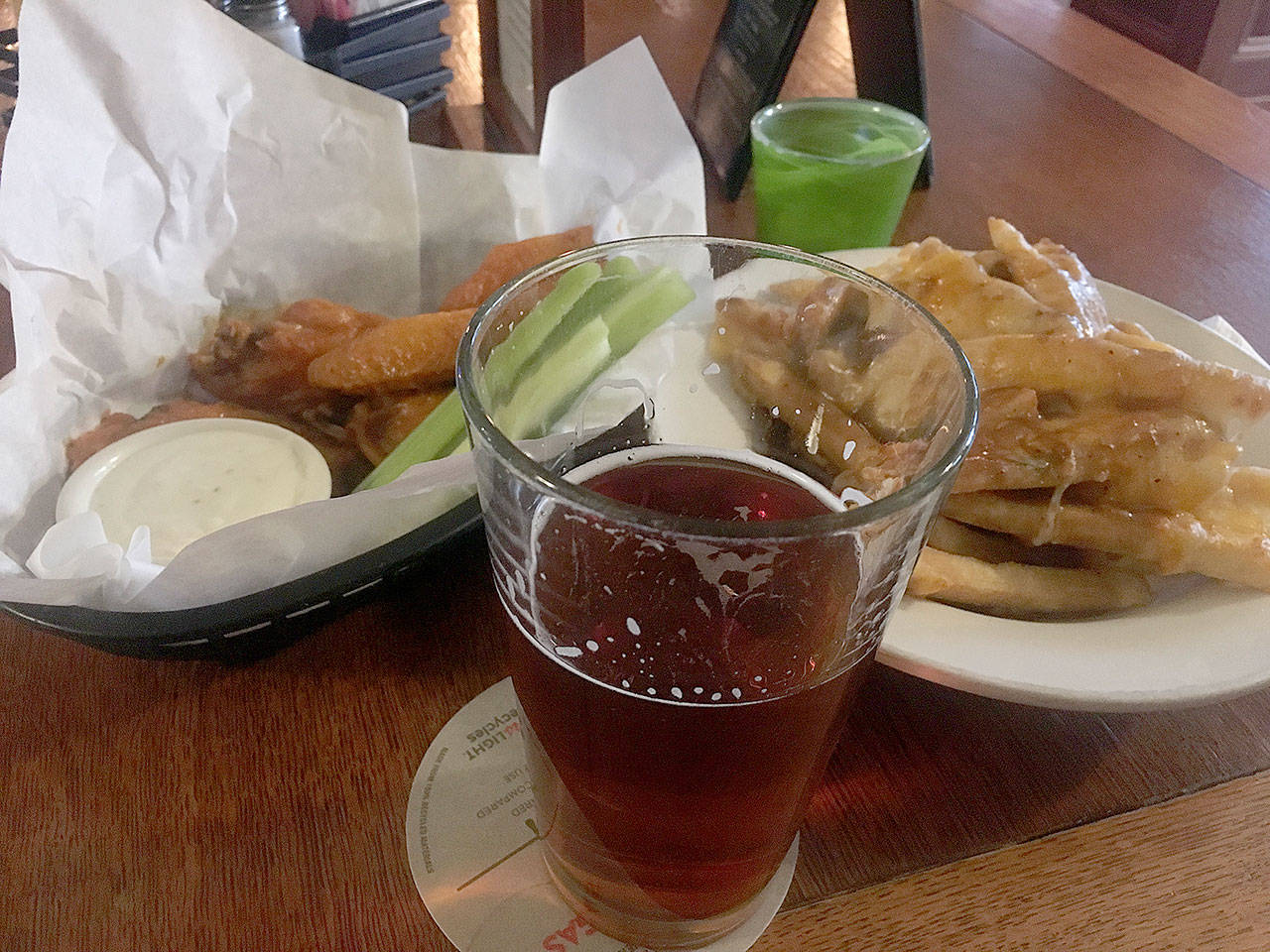 A Deschutes Fresh Squeezed IPA, an order of Buffalo wings and an order of Guinness gravy poutine were a happy hour treat at The Irishmen during a recent snowy day in Everett. (Ben Watanabe / The Herald)