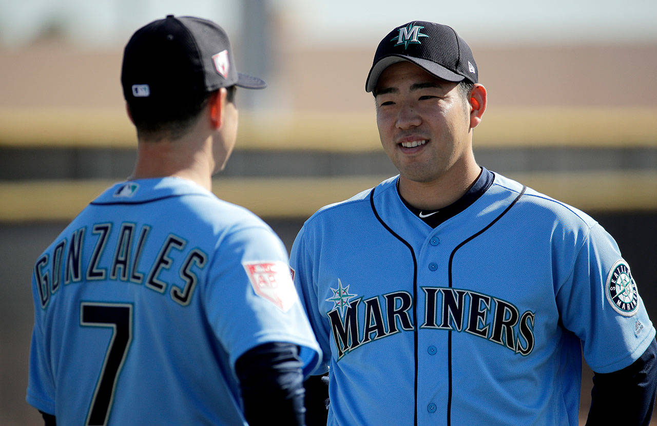 Seattle’s Yusei Kikuchi talks to fellow starting pitcher Marco Gonzales on Tuesday during a practice session in Peoria, Ariz. (AP Photo/Charlie Riedel)