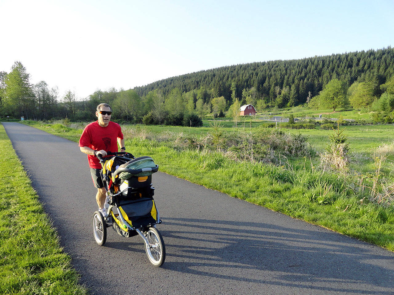 Craig Romano, author of a new outdoor recreation book on trails in the Everett area, runs on the Centennial Trail near the Nakashime Barn in Arlington. (Craig Romano)