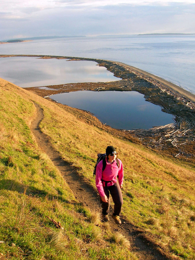 Heather Romano hiking the Bluff Trail at Ebey’s Landing Historical Reserve on Whidbey Island. (Craig Romano)
