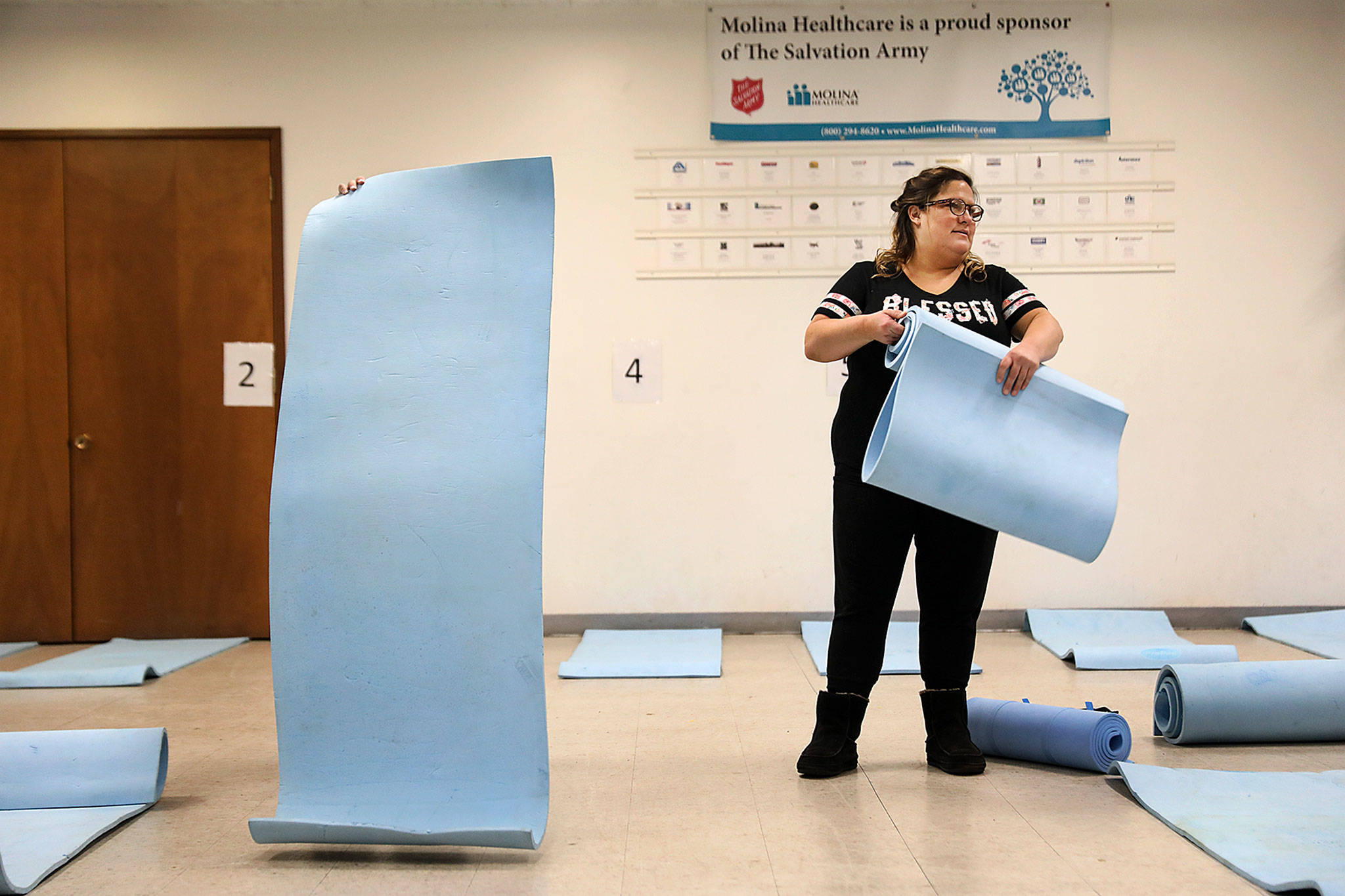 On Dec. 2nd, Andrea Reedy (left), a Salvation Army pastor and Jennifer Monger (right), a staff member, laid out mats as they prepared for the first night the cold weather shelter was open this winter. (Lizz Giordano / The Herald)