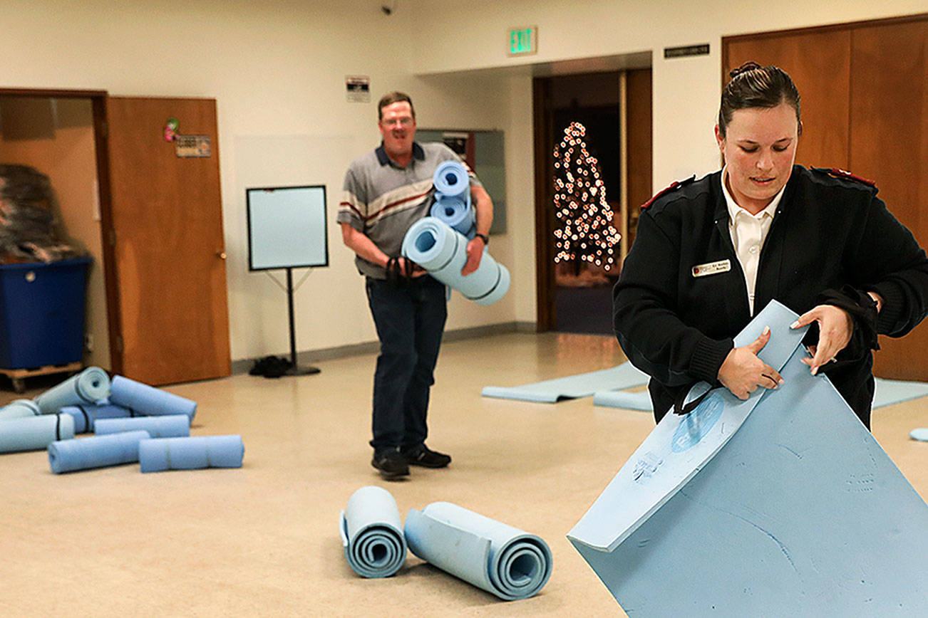 On Dec. 2nd, Andrea Reedy (right), a Salvation Army pastor laid out mats as she prepared for the first night the cold weather shelter was open this winter. (Lizz Giordano / The Herald)