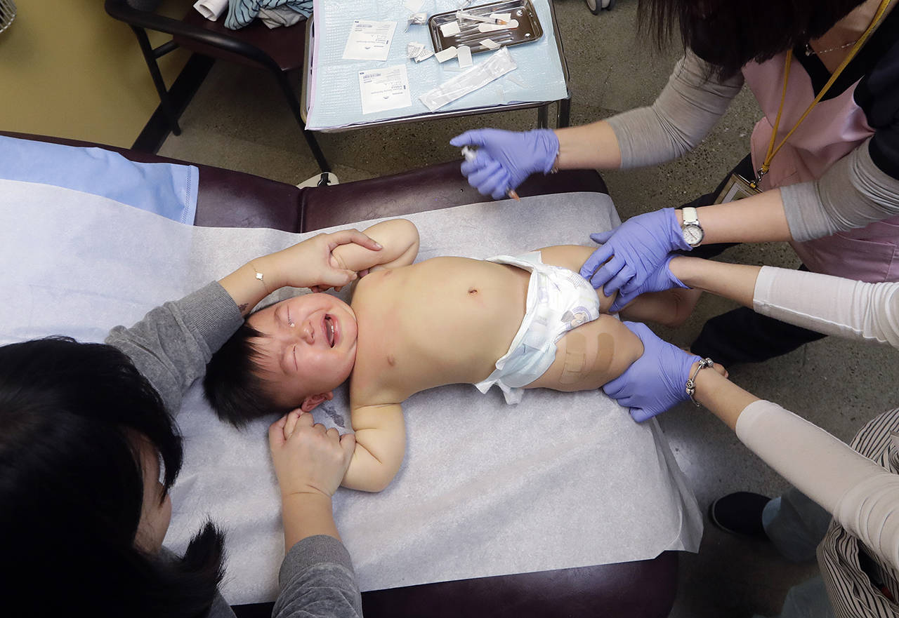 One-year-old Able Zhang cries as he receives the last of three inoculations, including a vaccine for measles, mumps, and rubella (MMR), at the International Community Health Services on Wednesday in Seattle. (AP Photo/Elaine Thompson)