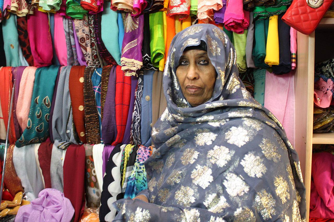 Nadifa Yusef, a Somalian immigrant and SeaTac shop owner, showcases some of her garments. They are traditional Somali dresses called dirac. (Aaron Kunkler / Seattle Weekly)