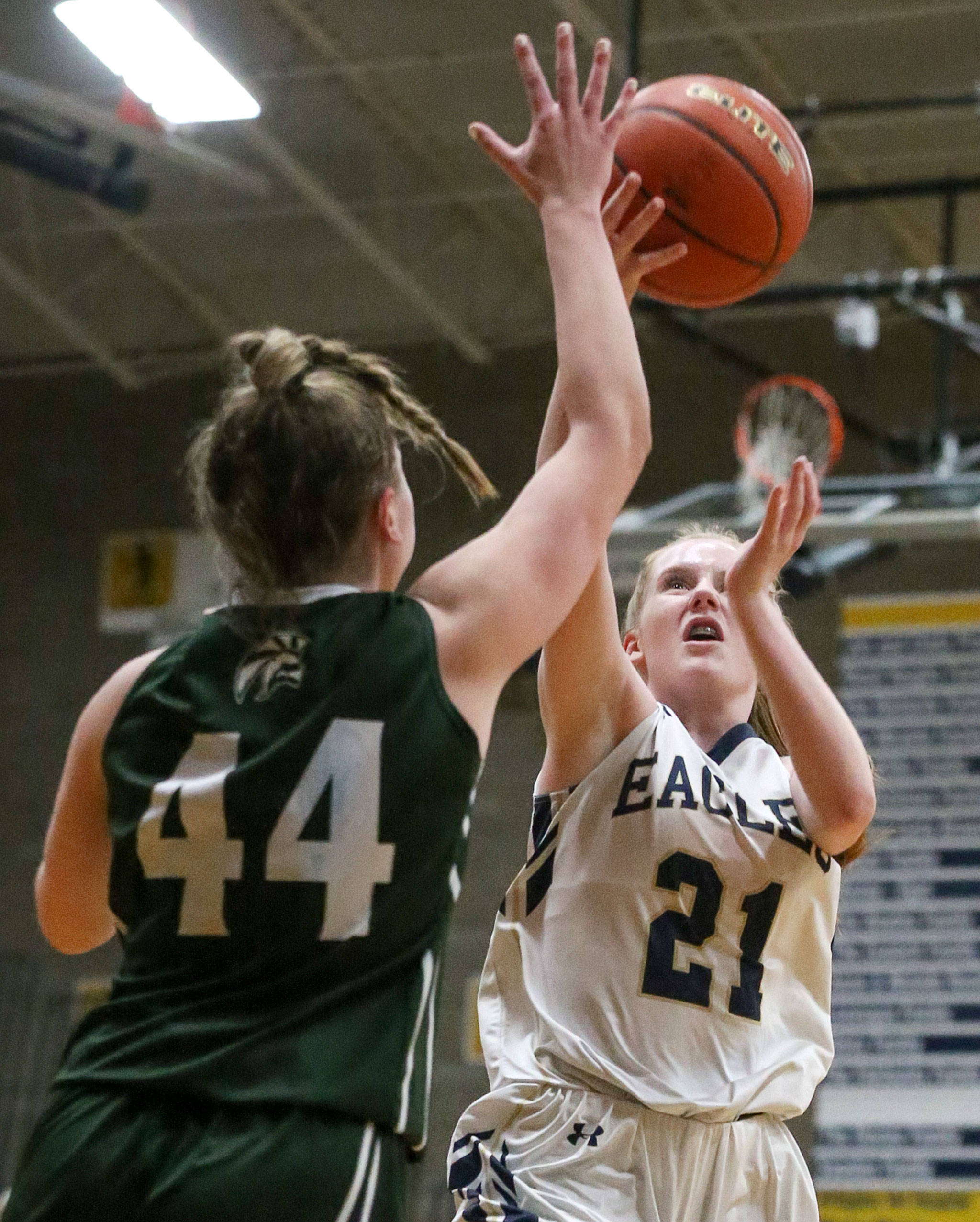 Arlington’s Josie Stupey attempts a shot with Edmonds-Woodway’s Adrienne Poling defending during the 3A district tournament Friday night at Arlington High on February 15, 2019 in Arlington. The Eagles won 55-38. (Kevin Clark / The Herald)