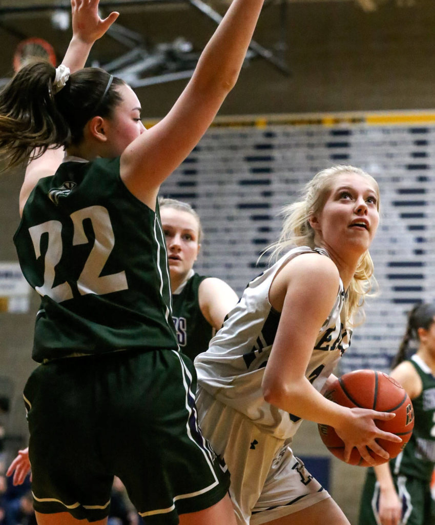 Arlington’s Abby Schwark looks for a shot with Edmonds-Woodway’s Maddie McMahon defending during the 3A district tournament Friday night at Arlington High on February 15, 2019 in Arlington. The Eagles won 55-38. (Kevin Clark / The Herald)
