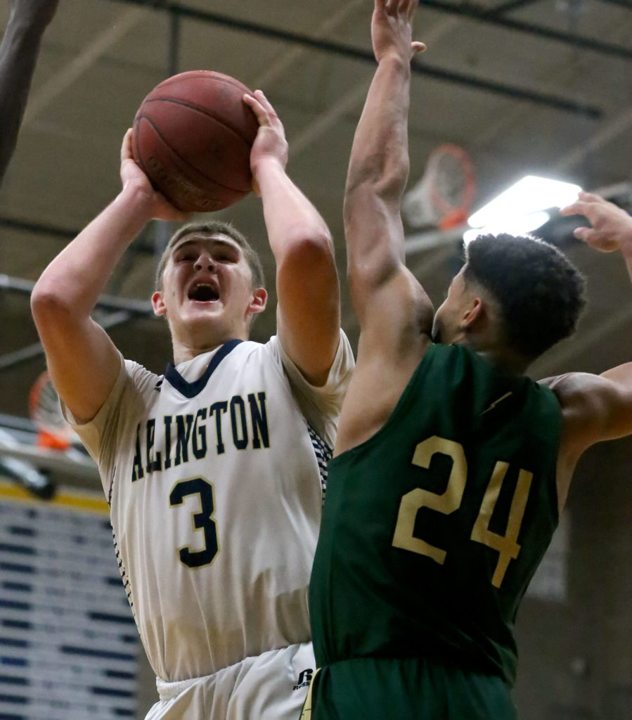 Arlington’s Griffin Gardoski attempts a shot with Marysville Getchell’s Malakhi Knight defending during Friday night’s Class 3A Northwest District semifinal. Gardoski scored a game-high 28 points as the Eagles clinched a state regional berth with a 65-52 win. (Kevin Clark / The Herald)
