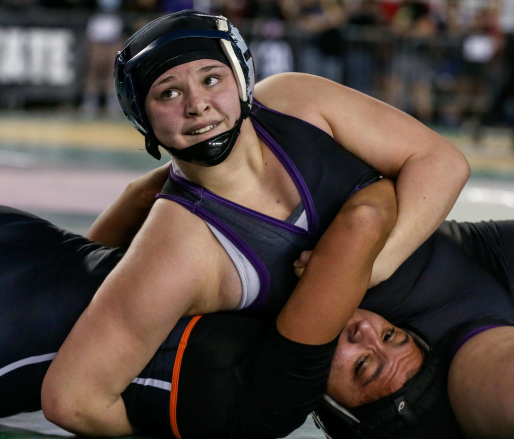 Lake Stevens’ Kiley Hubby looks to the clock as she works to pin Kennewick’s Alexia Asselin on Feb. 15, during the Mat Classic XXXI at the Tacoma Dome. Hubby advanced to the final in the 170 weight class. (Kevin Clark / The Herald)
