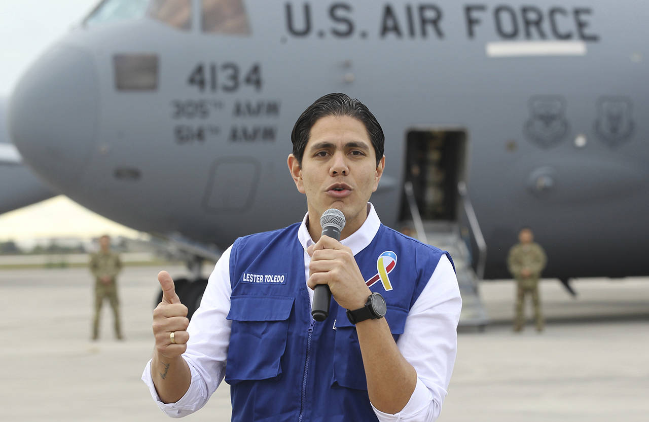 Lester Toledo from the Coalition Aid and Freedom Venezuela speaks in front of a C-17 cargo plane loaded with humanitarian commodities at Homestead Air Reserve Base on Saturday in Homestead, Florida. (AP Photo/Luis M. Alvarez)