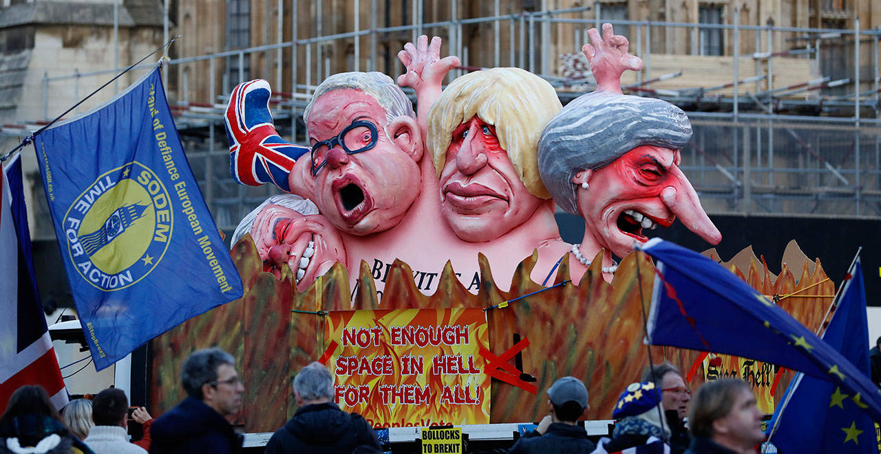 Anti-Brexit demonstrators stand next to a van with large cartoon style portraits of leading British politicians including, from right, Prime Minister Theresa May, Boris Johnson, Michael Gove, David Davis, outside the Palace of Westminster in London on Feb. 14. British lawmakers are holding another series of votes on Brexit legislation Thursday. (AP Photo/Alastair Grant)