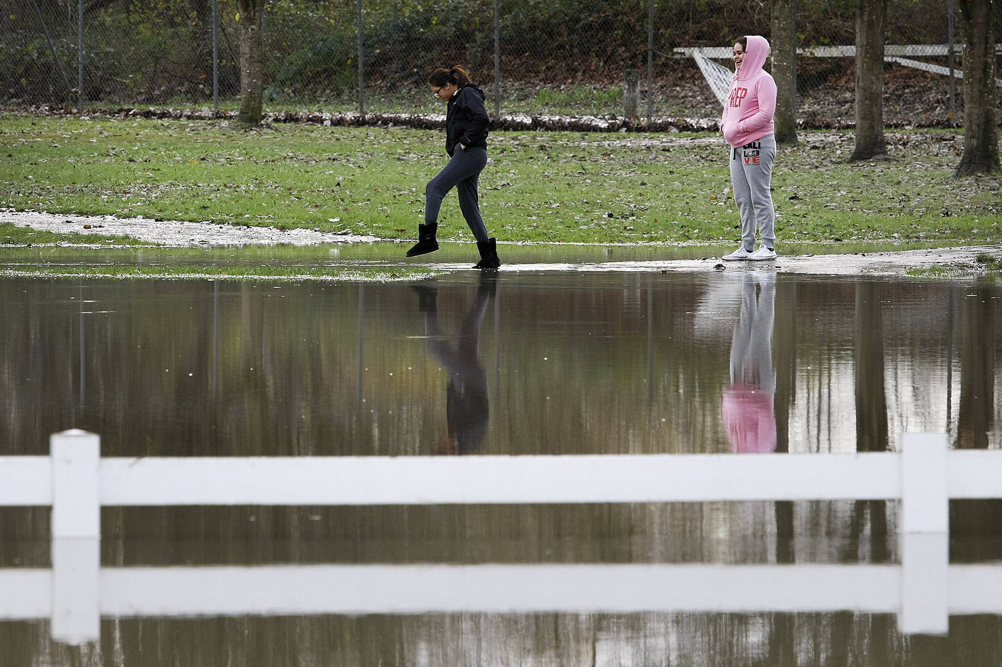 People tiptoe through flood waters in November 2015, at Skykomish River Centennial Park in Monroe. (Ian Terry / Herald file)