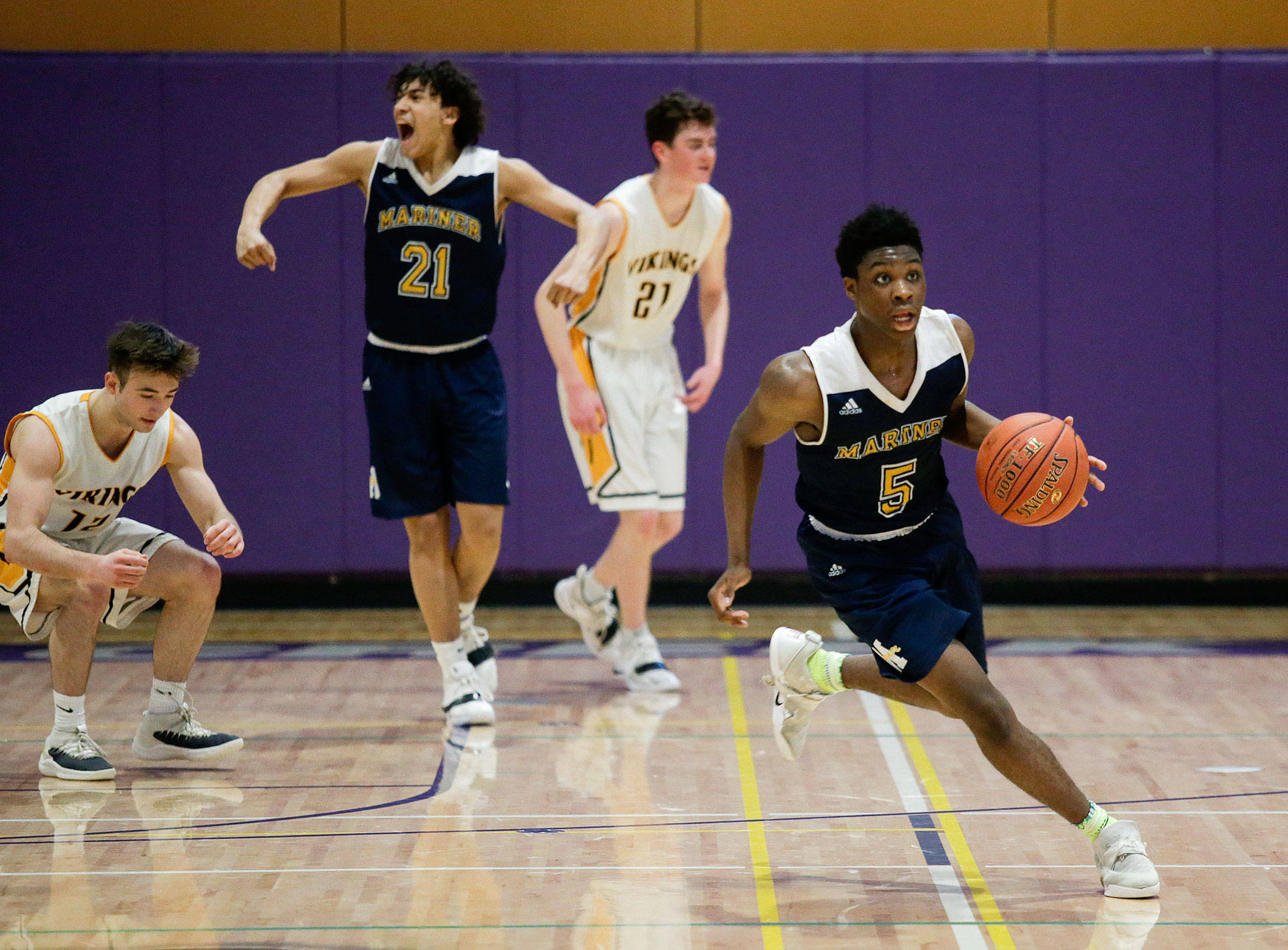 Mariner’s Tony MacArthur (21) begins to celebrate as Edwin Bough watches the clock hit zero Monday, Feb. 18, as the Marauders beat Inglemoor 50-47 in a Class 4A Wes-King District Tournament game at North Creek High in Bothell. (Andy Bronson / The Herald)