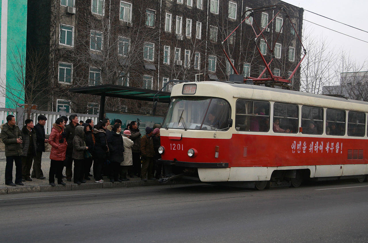 People queue up to board a tram in Pyongyang, North Korea, on Feb. 2. Pyongyang is upgrading its overcrowded mass transit system with brand new subway cars, trams and buses in a campaign meant to show leader Kim Jong Un is raising the country’s standard of living. (AP Photo/Dita Alangkara)