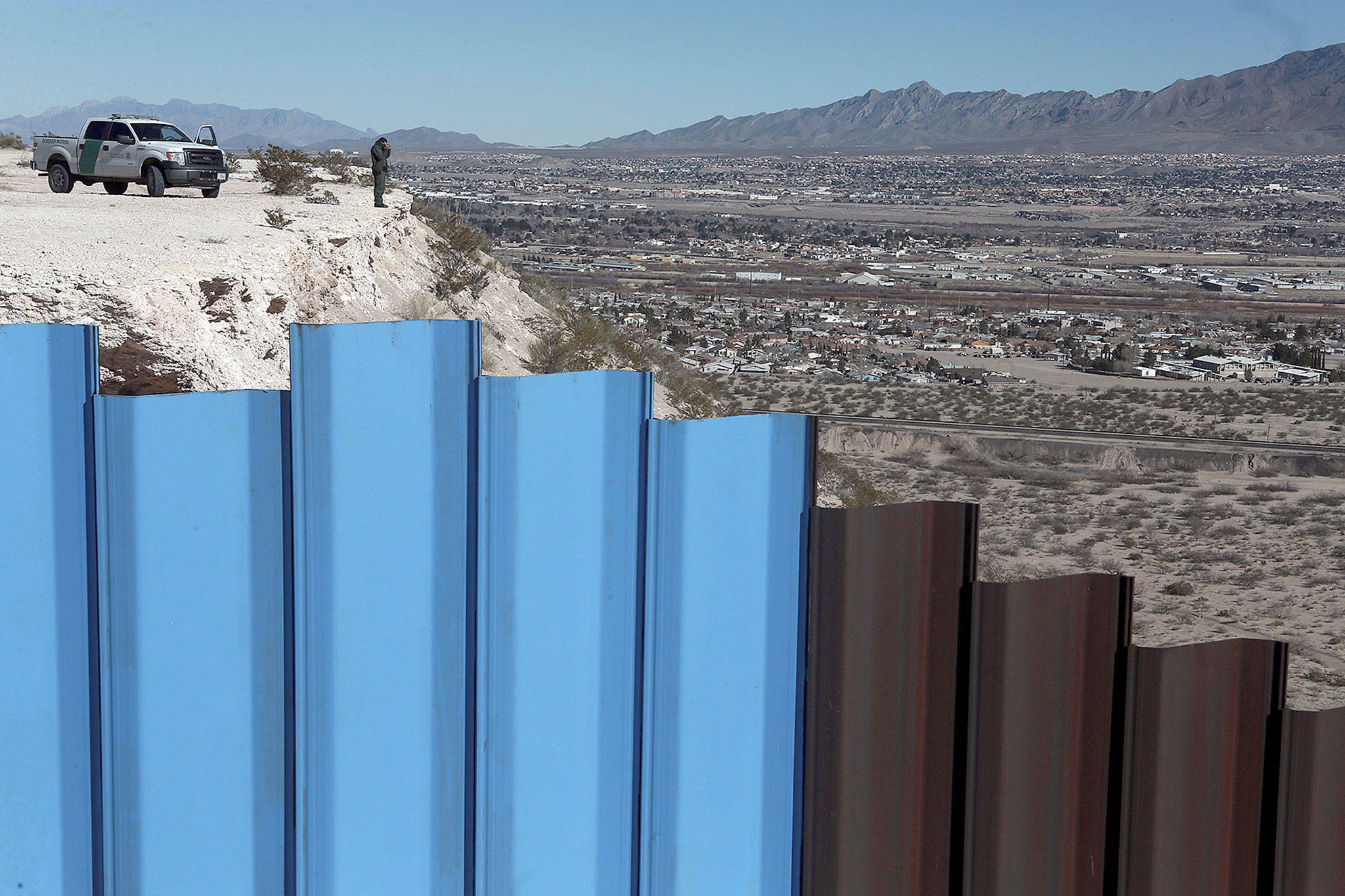 An agent from the border patrol observes near the Mexico-US border fence separating the towns of Anapra, Mexico, and Sunland Park, New Mexico. (AP Photo/Christian Torres, File)